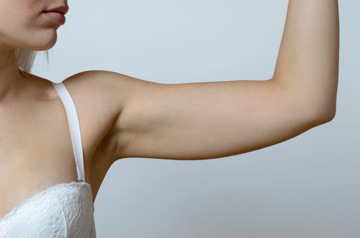Young blond woman showing flabby arm