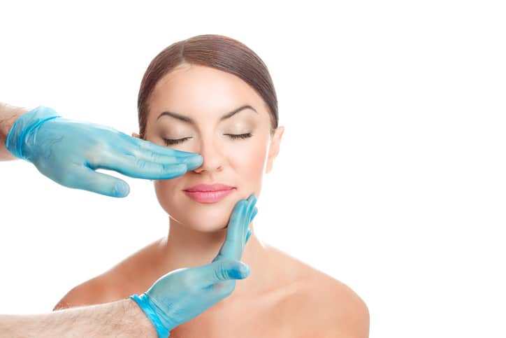 Woman is preparing for nose surgery, white background