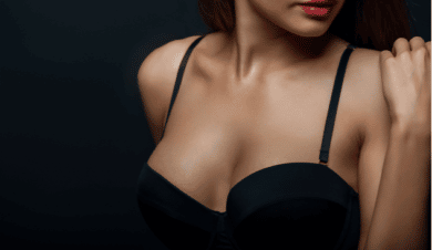 Close up of breast of attractive woman presenting her black bra.
