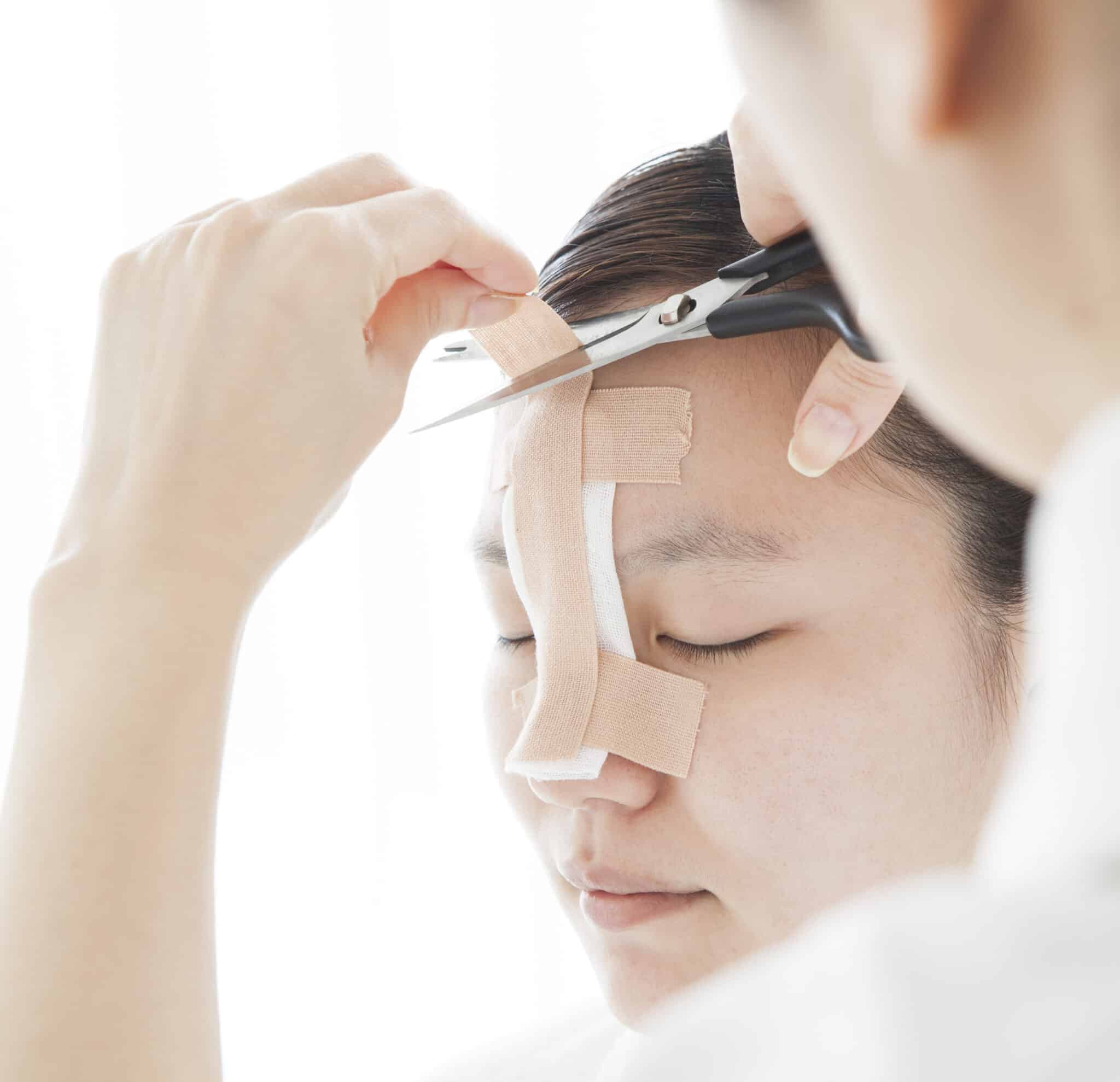 Doctor to taping a patient's nose