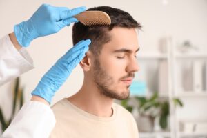 Doctor combing through man's freshly restored head of hair after reconstructive hair transplant