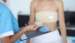Doctor with patient holding breast implant to discuss reconstructive breast surgery.