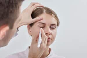 Doctor marking woman's eyelids to prepare for eyelid surgery