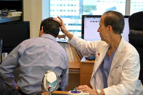 Dr. Barrera consults with hair transplant patient.